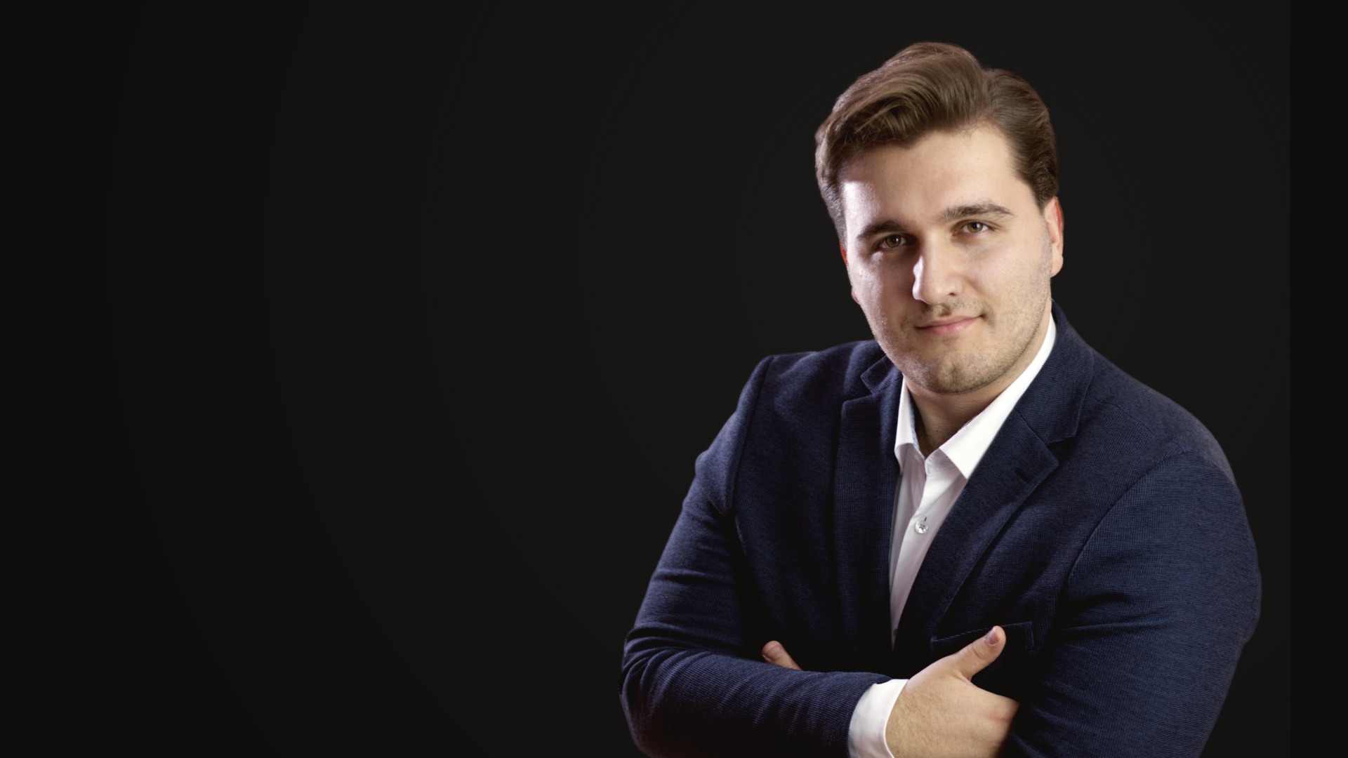 Zivko Gvozdenovic, founder of Hot Iron Studio, arms crossed, in a dark jacket against a dark ground.